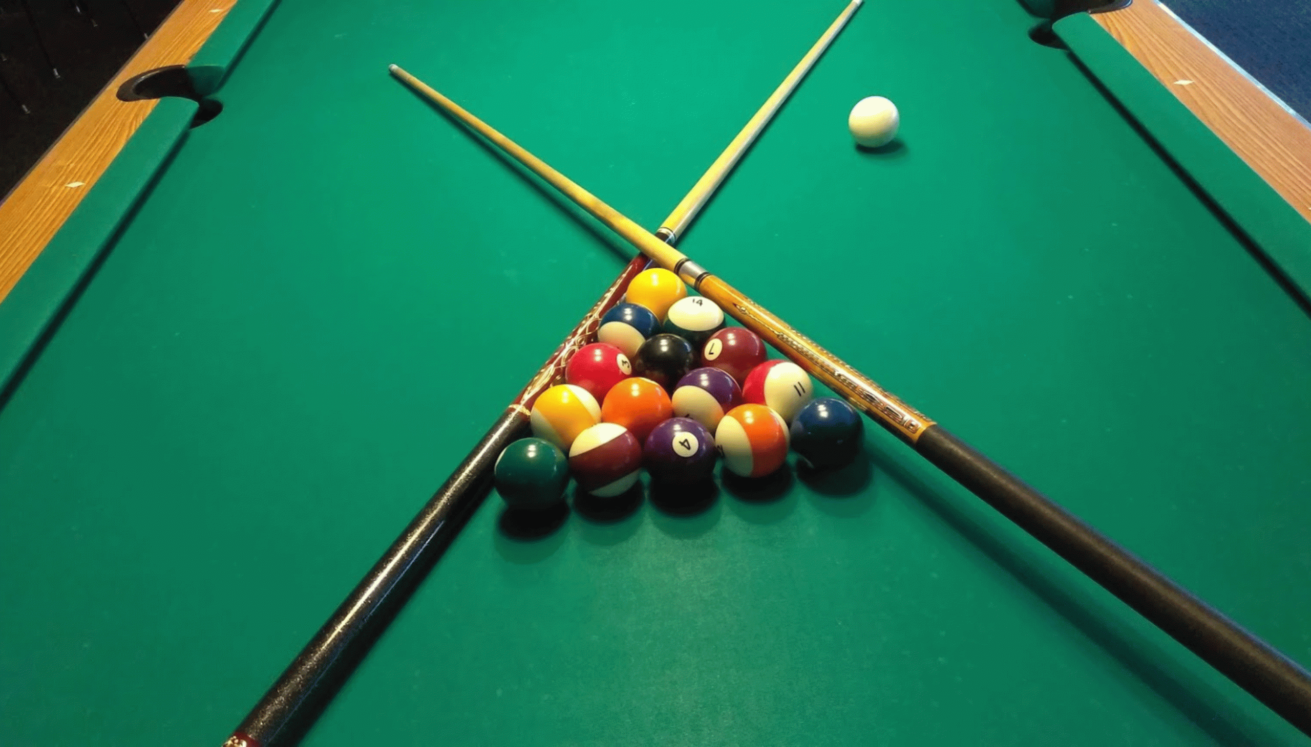 Pool balls racked with pool cues